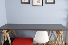 Вид рабочего столика в современном интерьере с стулом и украшенной стеной.